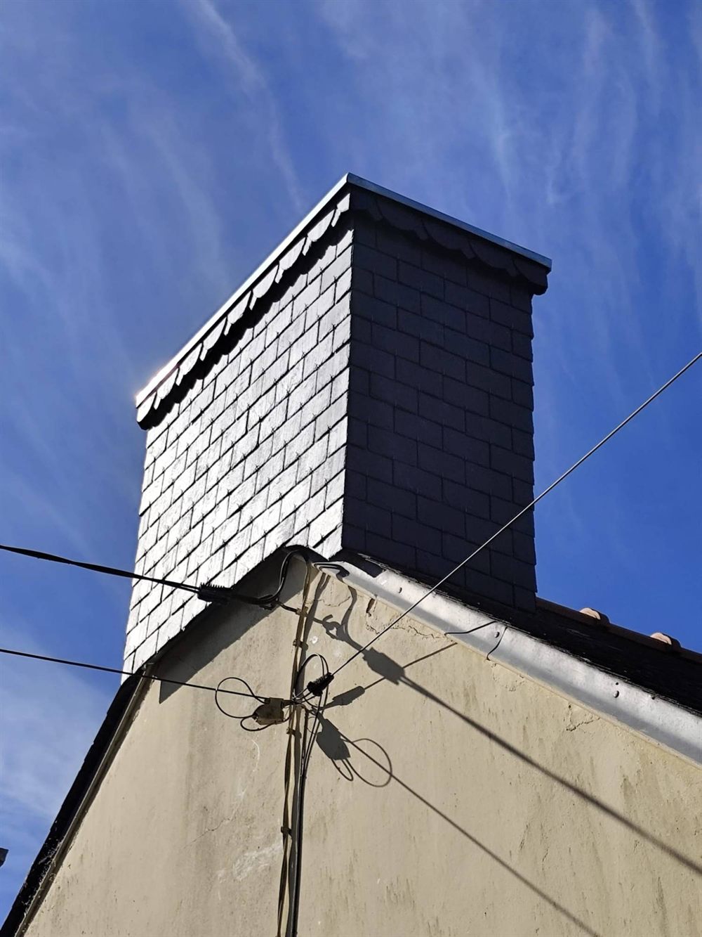 Après : habillage en ardoise naturelle avec frise festonnée et couvertine zinc, réalisé par ALF Couverture